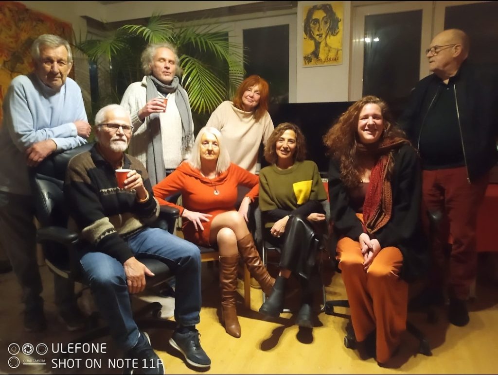 Visite d’atelier à Ixelles : photo de groupe avec l’artiste Jérôme Selosse entouré de sa famille et d’amis devant ses œuvres.