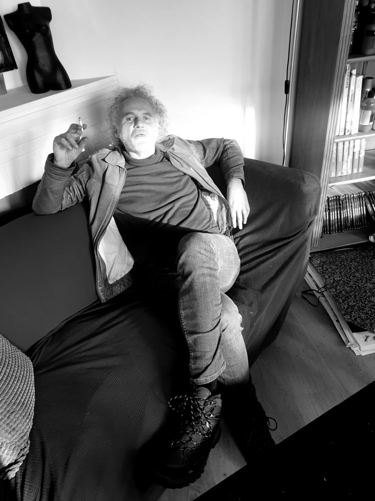 Portrait photographique en noir et blanc de Jérôme Selosse, artiste peintre contemporain bruxellois, en posture contemplative.