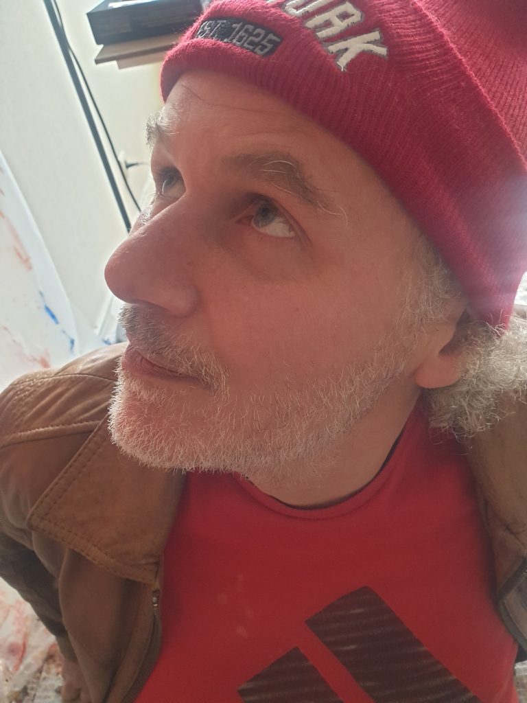 Portrait de l'artiste peintre Jérôme Selosse dans son atelier, écoutant l'analyse de ses œuvres par l'intelligence artificielle.