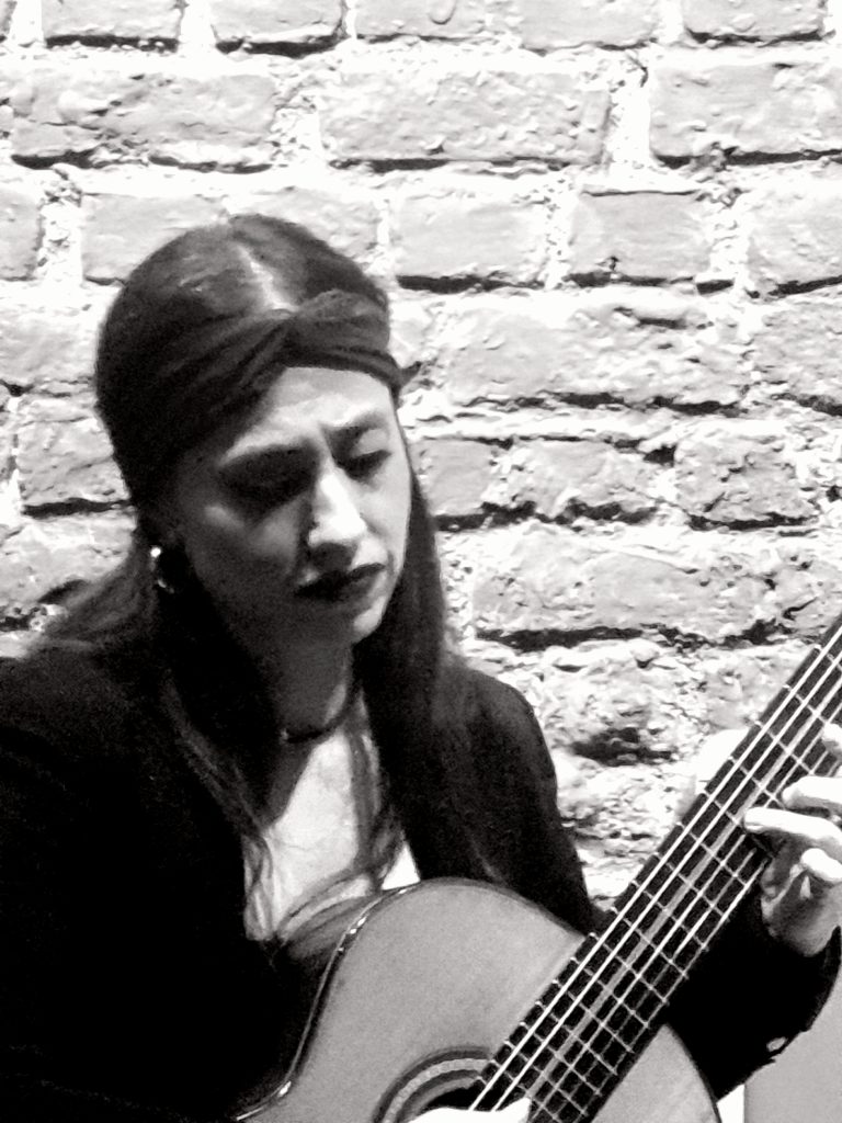 Photographie en noir et blanc de la guitariste Ana Santisteban jouant de la guitare classique. Portrait de la musicienne du Trío Azahar concentrée pendant l'interprétation de Capricho espagnol. Photographie Jérôme Selosse. Cambre Expo.